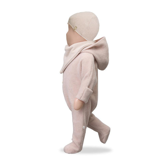Baby in a pink outfit with a matching hat on a white background