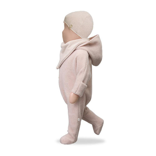 Baby in a pink outfit with a matching hat on a white background