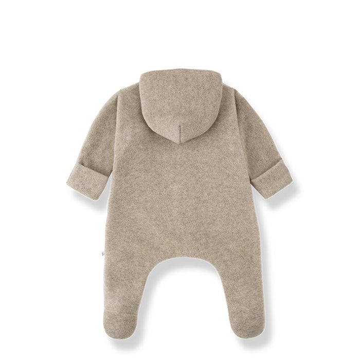 A light taupe-beige hooded footless one-piece baby romper shown from the back, featuring long sleeves and integrated leg cuffs, photographed on a clean white background.