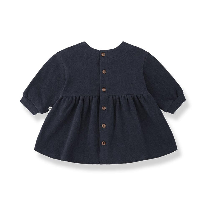 A navy blue short-sleeve baby top with a gathered peplum waist and a front button closure, shown against a plain white background.
