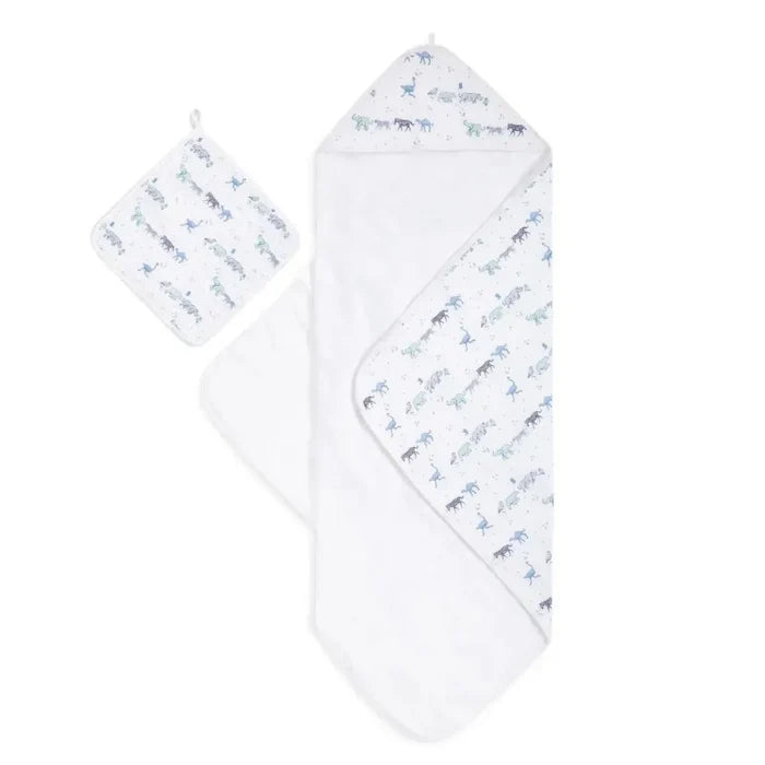 A white muslin baby towel set featuring a hooded wrap blanket and a matching square muslin cloth, both printed with a repeating pattern of blue and gray cartoon animals on a white background.