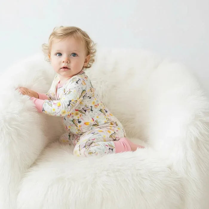 Child sitting on a fluffy white bean bag chair against a plain background