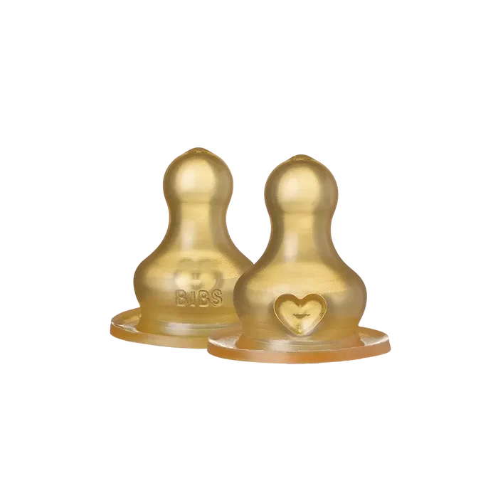 Two gold-colored baby bottle nipples on a white background