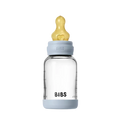 Clear baby bottle with gold nipple and blue cap on a white background