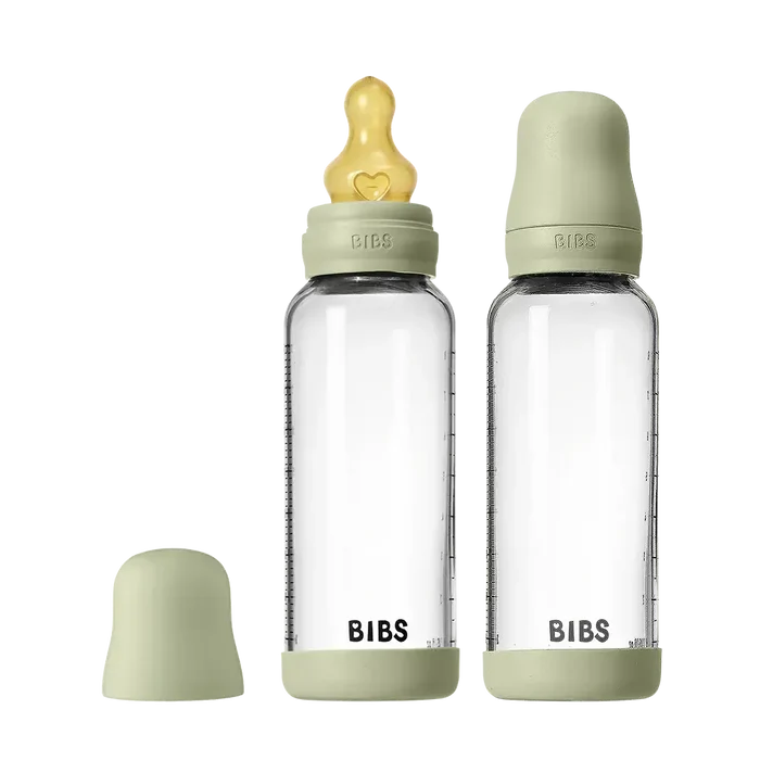 Two clear baby bottles with green caps and nipples on a white background, featuring the brand 'Bibs'.