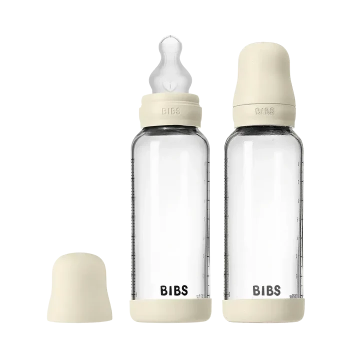 Two clear baby bottles with beige caps and 'Bibs' branding on a white background