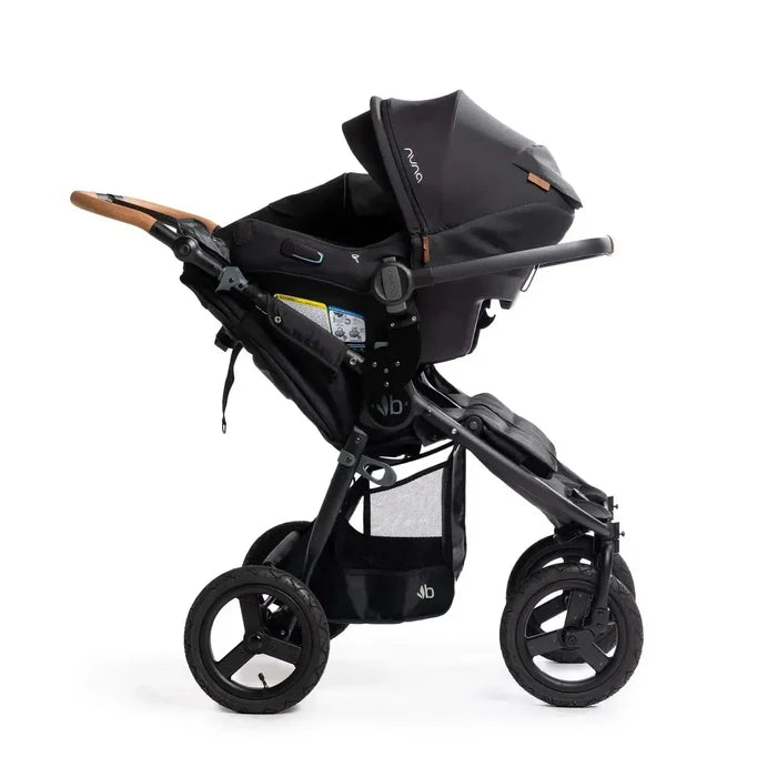 Side view of black stroller with one car seat attached on a white background