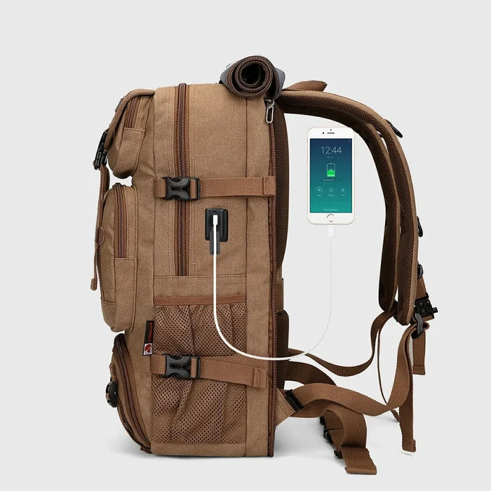 Side view of brown canvas travel backpack with USB charging port and padded shoulder straps