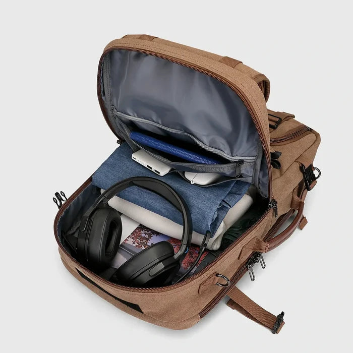 Brown canvas travel backpack with spacious main compartment open for clothes and travel essentials