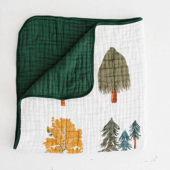 Green fabric with forest-themed pattern on a white background