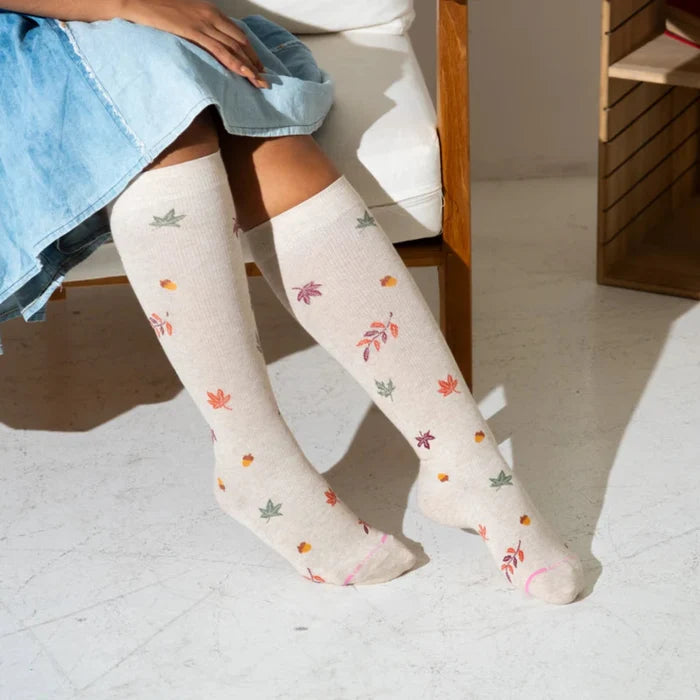 Woman wearing knee high compression socks fall foliage for daily comfort and circulation