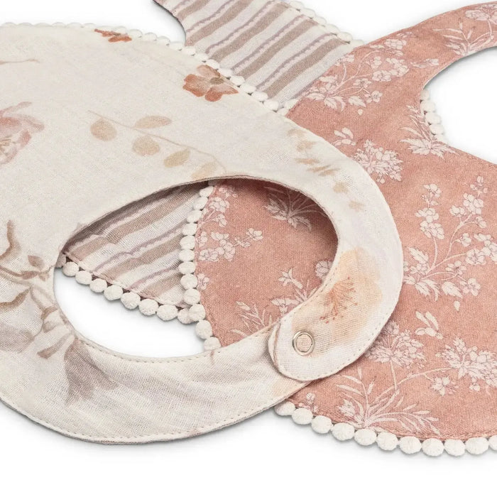 Floral-patterned bib with decorative trim on a white background