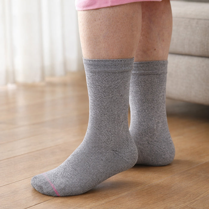 Person wearing gray socks on a wooden floor