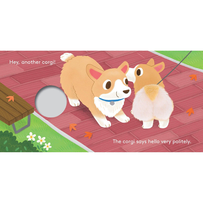 A children's board book or activity book page featuring an illustrated scene of two corgis on a red brick path with leaves, a bench, grass, and white text reading 'Hey, another corgi!' and 'The corgi says hello very politely.' A circular hole is visible on the left side of the page.