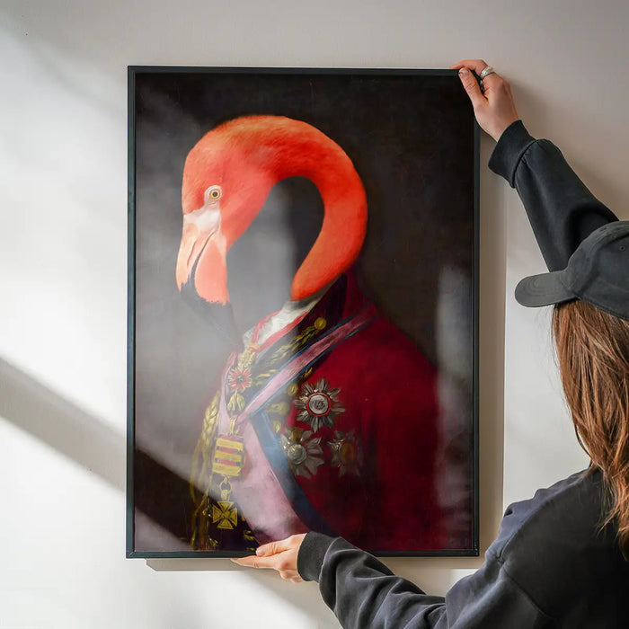 Flamingo Portrait Print being hung on a wall in a black frame