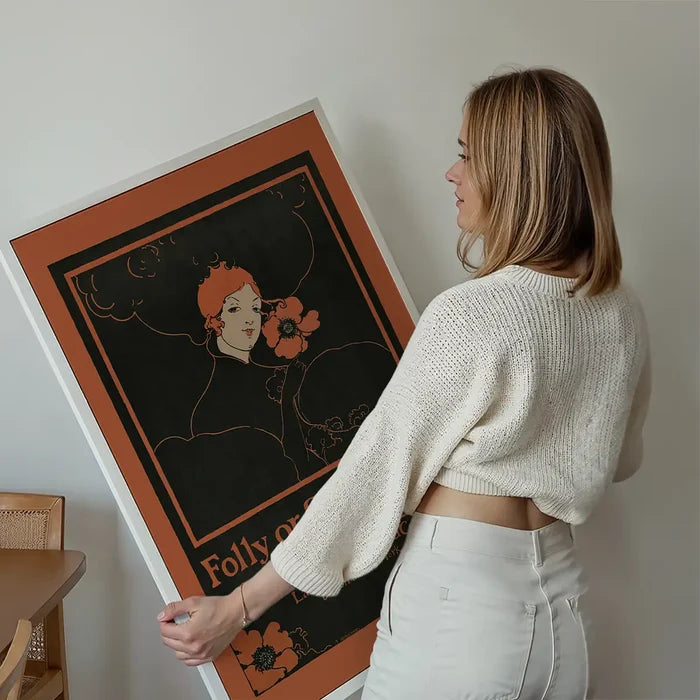 Folly or Saintliness vintage poster of a woman by Ethel Reed held up against a living room wall
