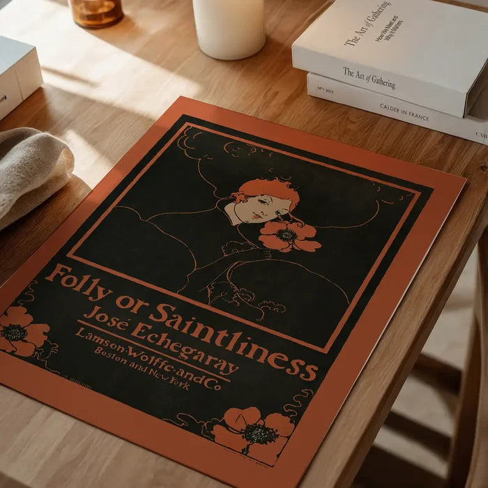 Folly or Saintliness vintage poster of a woman by Ethel Reed unframed on a home office desk