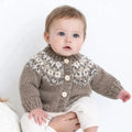 Baby wearing a knitted sweater with a patterned collar on a white background