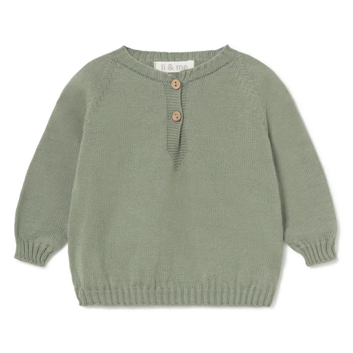 A sage green knit baby sweater with three wooden buttons on the chest, laid flat against a white background.