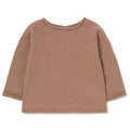 A long-sleeve knit top in a dusty rose or mauve color, laid flat against a solid white background.