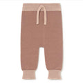 A pair of knit baby pants in a dusty rose color with contrasting light pink ribbed waistband and cuffs, featuring a front split design and drawstring.