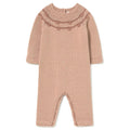 A dusty pink hand-knit baby jumpsuit with a decorative patterned yoke, shown flat on a white background.