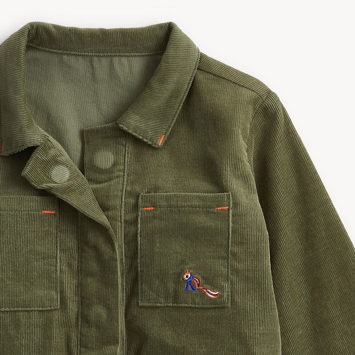 Close-up of an olive green corduroy jacket with a pointed collar, snap-button placket, flap chest pocket, and a small embroidered fox patch on the pocket. Image depicts magnetic closure.