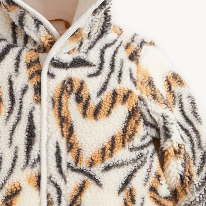 Close-up of a sherpa fleece romper with a tiger-stripe pattern in black, brown, and beige on a white background.