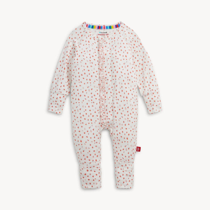 A baby long-sleeve romper with a white base, covered in a small pink apple pattern, and a ruffled front placket.