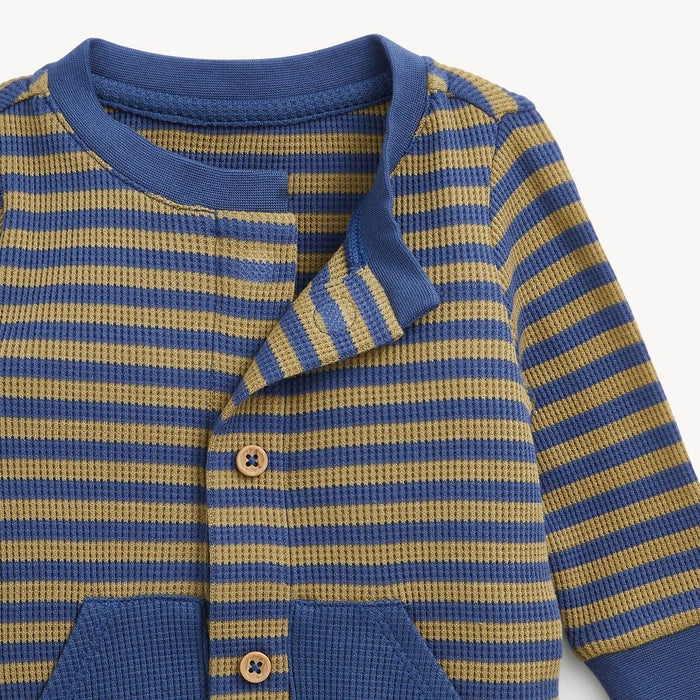 Close-up of a baby knot romper with horizontal blue and olive yellow stripes, featuring a blue collar, button closure, and front pockets.