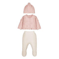 A three-piece baby clothing set including a light pink knit cardigan with a pom-pom beanie, and cream ribbed footed pants, displayed on a solid white background.