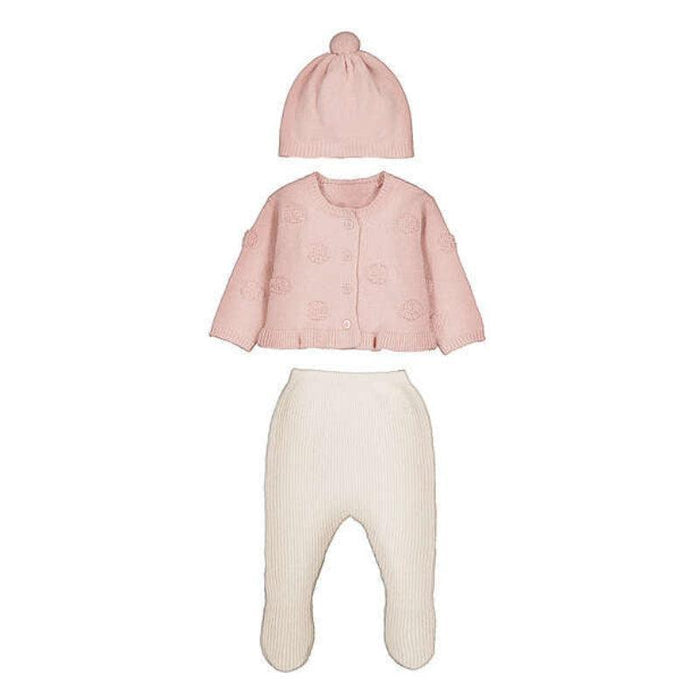 A three-piece baby clothing set including a light pink knit cardigan with a pom-pom beanie, and cream ribbed footed pants, displayed on a solid white background.
