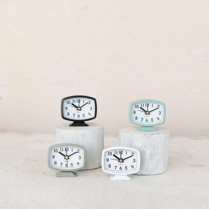 Set of four small clocks on a light background