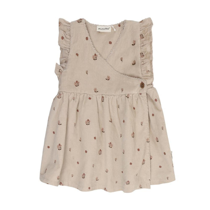 A sleeveless beige baby dress with a small brown floral print, featuring ruffled shoulders and a wrap-style V-neckline, shown against a plain white background.