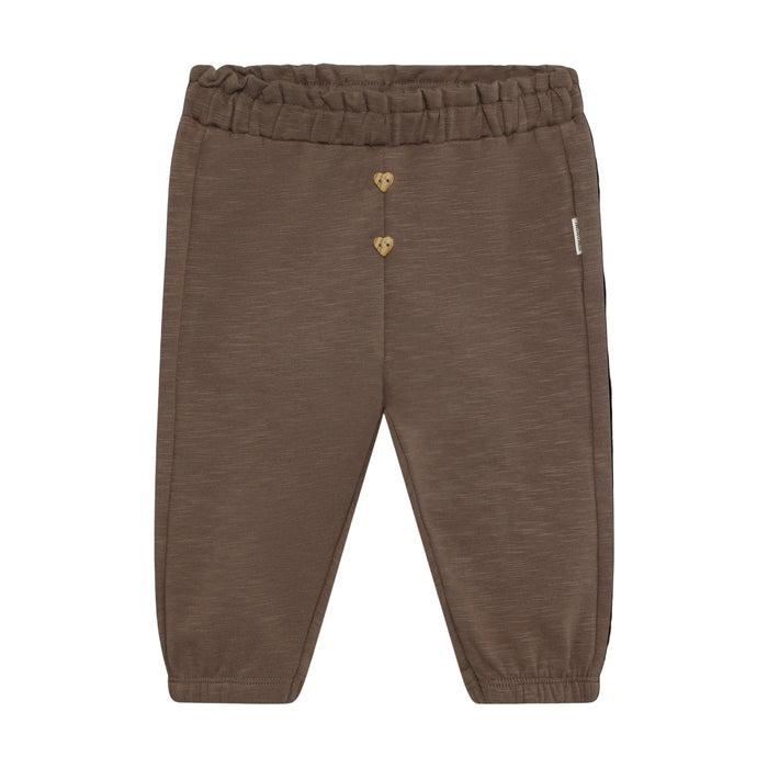 A pair of toddler jogger pants in a heathered brown fabric, featuring a gold heart-shaped button closure at the waist and a small white brand tag on the side, set against a solid black background.