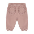 A pair of dusty rose pink corduroy pants for toddlers, shown from the back. The pants feature an elastic waistband, two decorative ruffled patch pockets, and elasticated cuffs at the ankles, photographed against a solid white background.