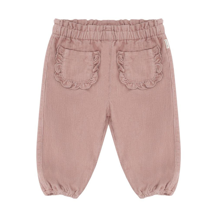 A pair of dusty rose pink corduroy pants for toddlers, shown from the back. The pants feature an elastic waistband, two decorative ruffled patch pockets, and elasticated cuffs at the ankles, photographed against a solid white background.
