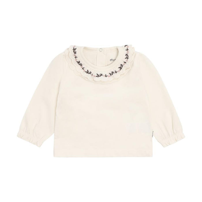 An off-white long-sleeve baby top with a ruffled collar decorated with black embroidered leaves, shown flat on a white background.