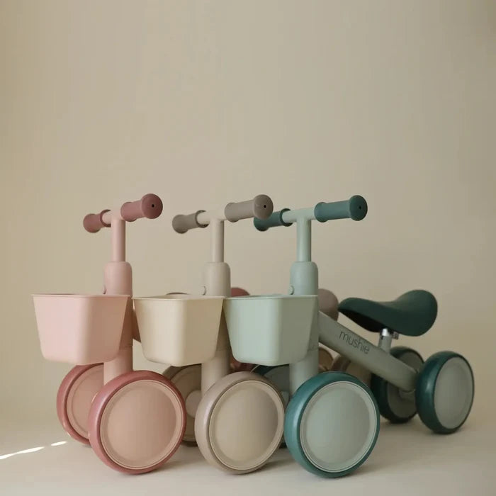Set of colorful children's balance bikes on a beige background