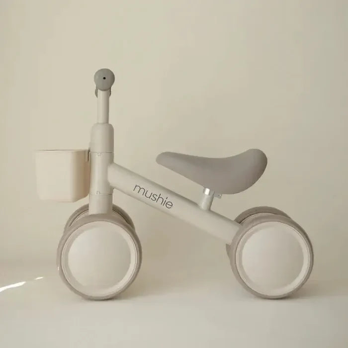 Children's balance bike with 'mushie' branding on a plain background