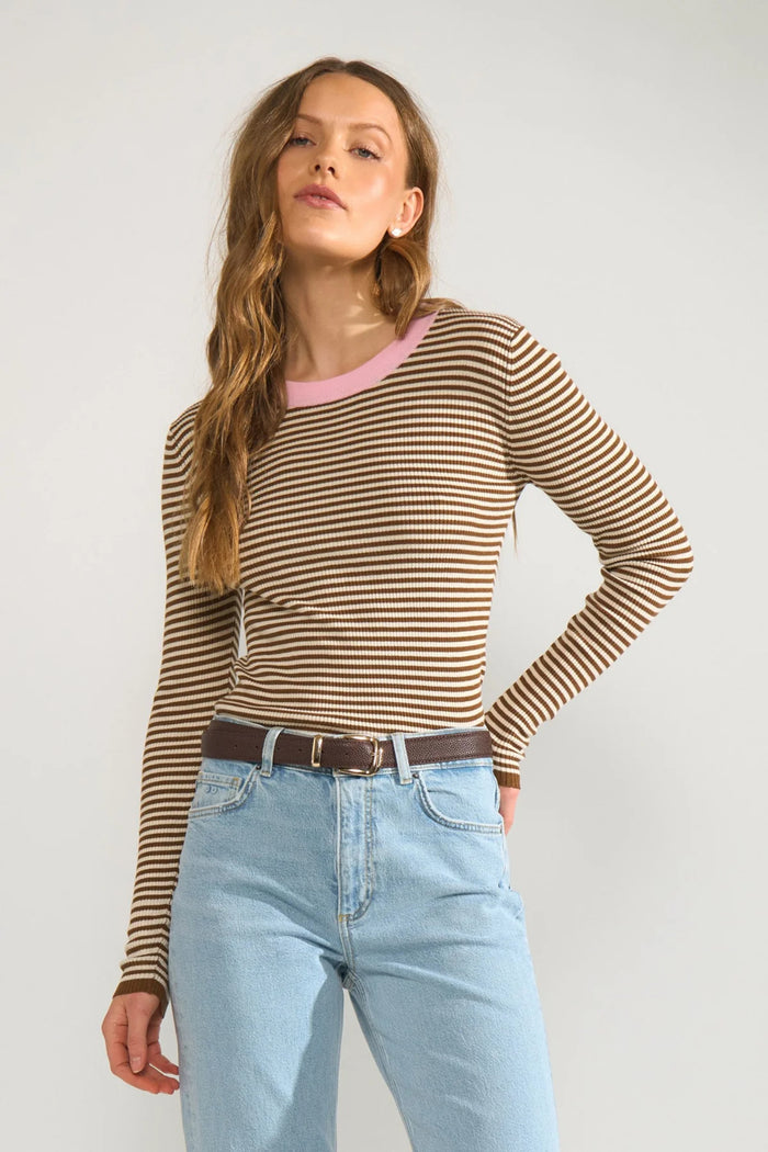 Model wearing Numph 706923 NUFILINA Pullover – Dachshund with brown and cream stripes and a pink neckline, paired with light blue jeans by Numph. Shop Numph at Dotique.