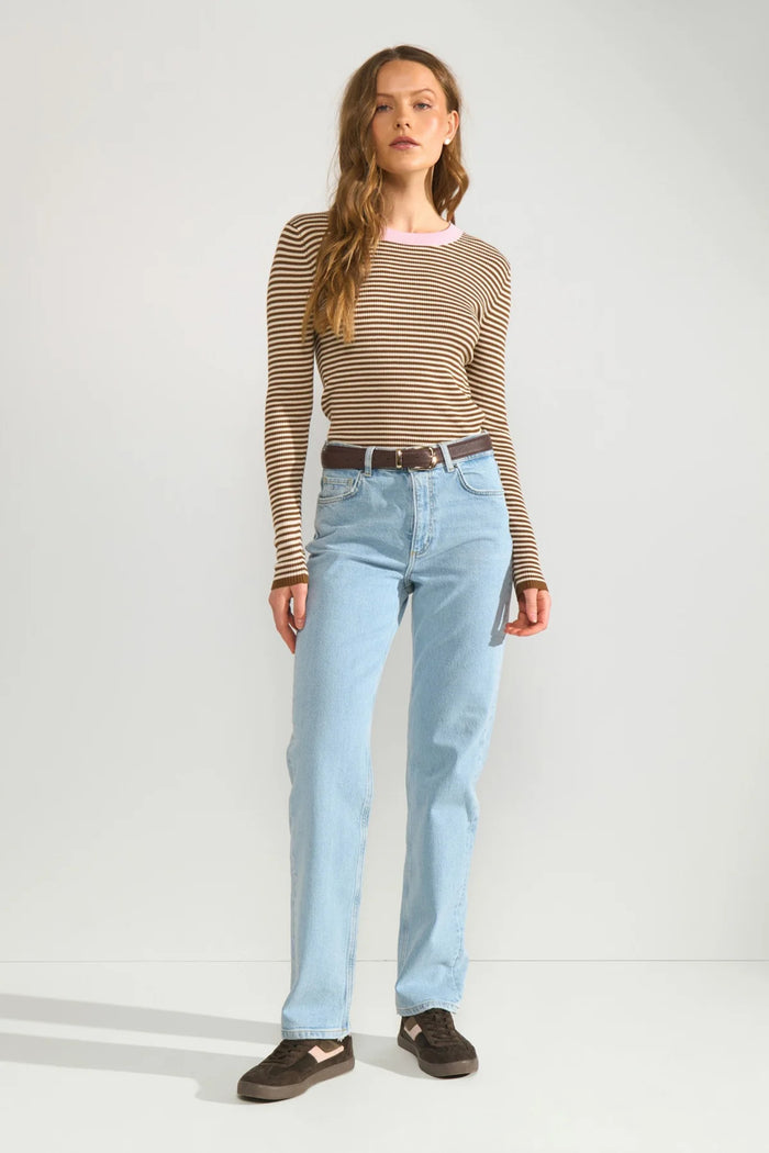 Model wearing Numph 706923 NUFILINA Pullover – Dachshund with narrow brown and beige stripes, paired with light blue jeans and dark sneakers by Numph. Shop Numph at Dotique.