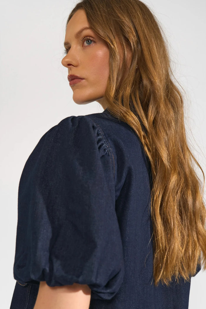 Model showcasing the puffed sleeve detail on the Numph 707020 NUALETTA SS Shirt – Dark Blue Denim by Numph. Shop Numph at Dotique.