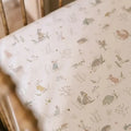 Crib sheet with animal pattern on a wooden crib