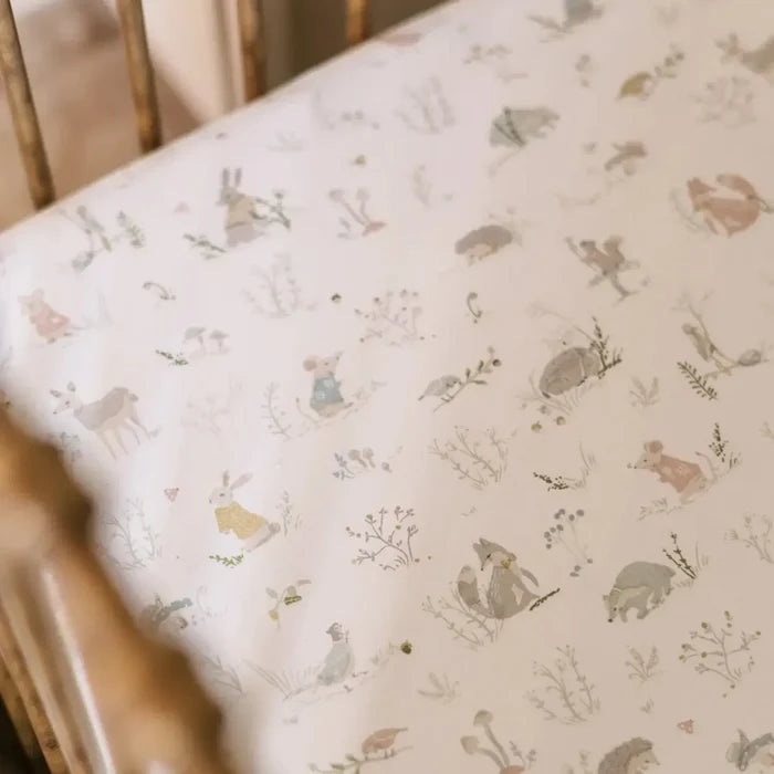 Crib sheet with animal pattern on a wooden crib