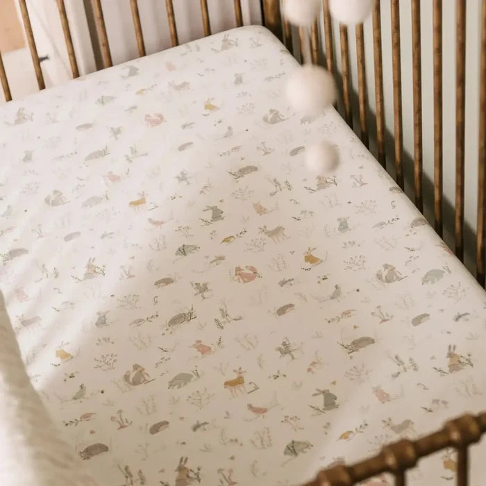 Crib with patterned sheet and wooden crib bars