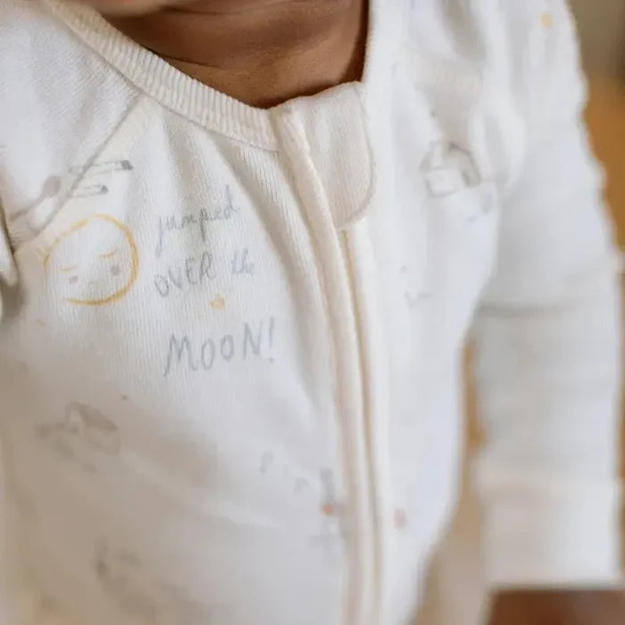 Close-up of a child wearing a white hoodie with text, blurred background