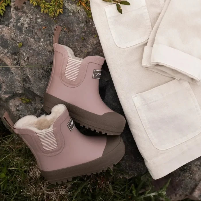White coat and pink boots on a natural background