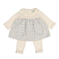 A baby girl's two-piece outfit set featuring a long-sleeve cream top with ruffle trim and a matching cream-and-beige gingham skirt with two front pockets, paired with matching cream leggings.