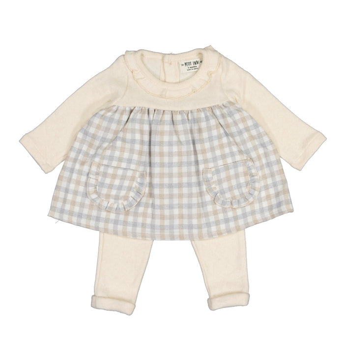 A baby girl's two-piece outfit set featuring a long-sleeve cream top with ruffle trim and a matching cream-and-beige gingham skirt with two front pockets, paired with matching cream leggings.